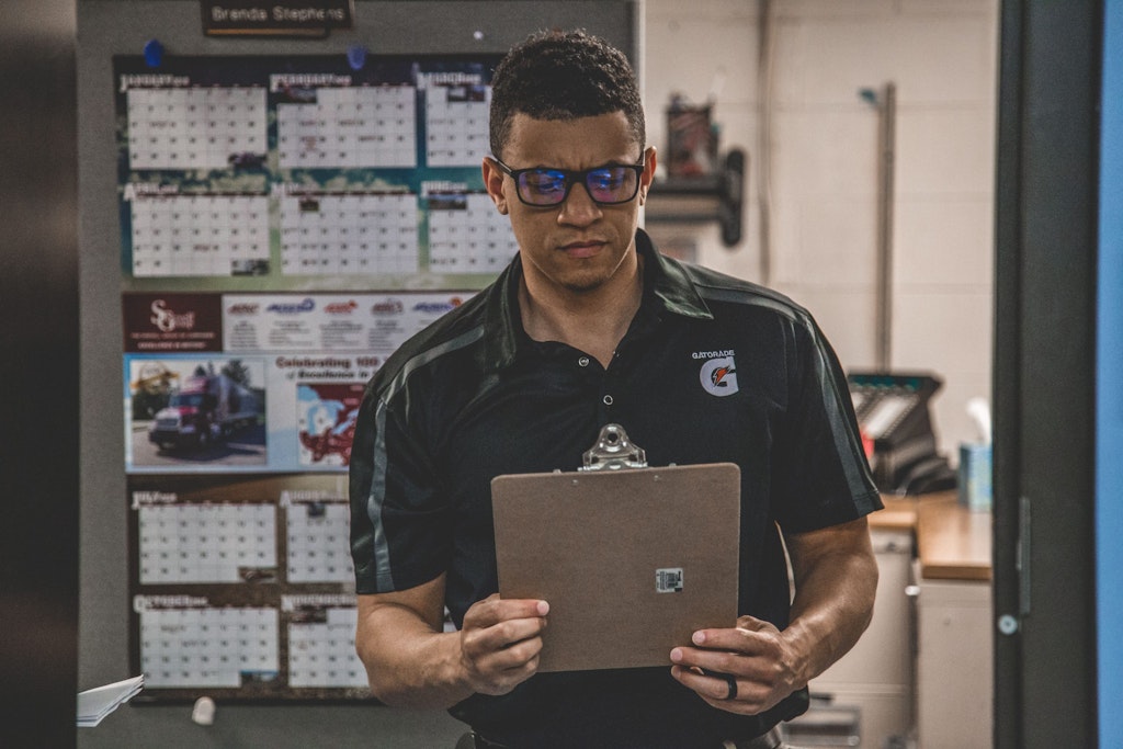 black man holding a clipboard in warehouse