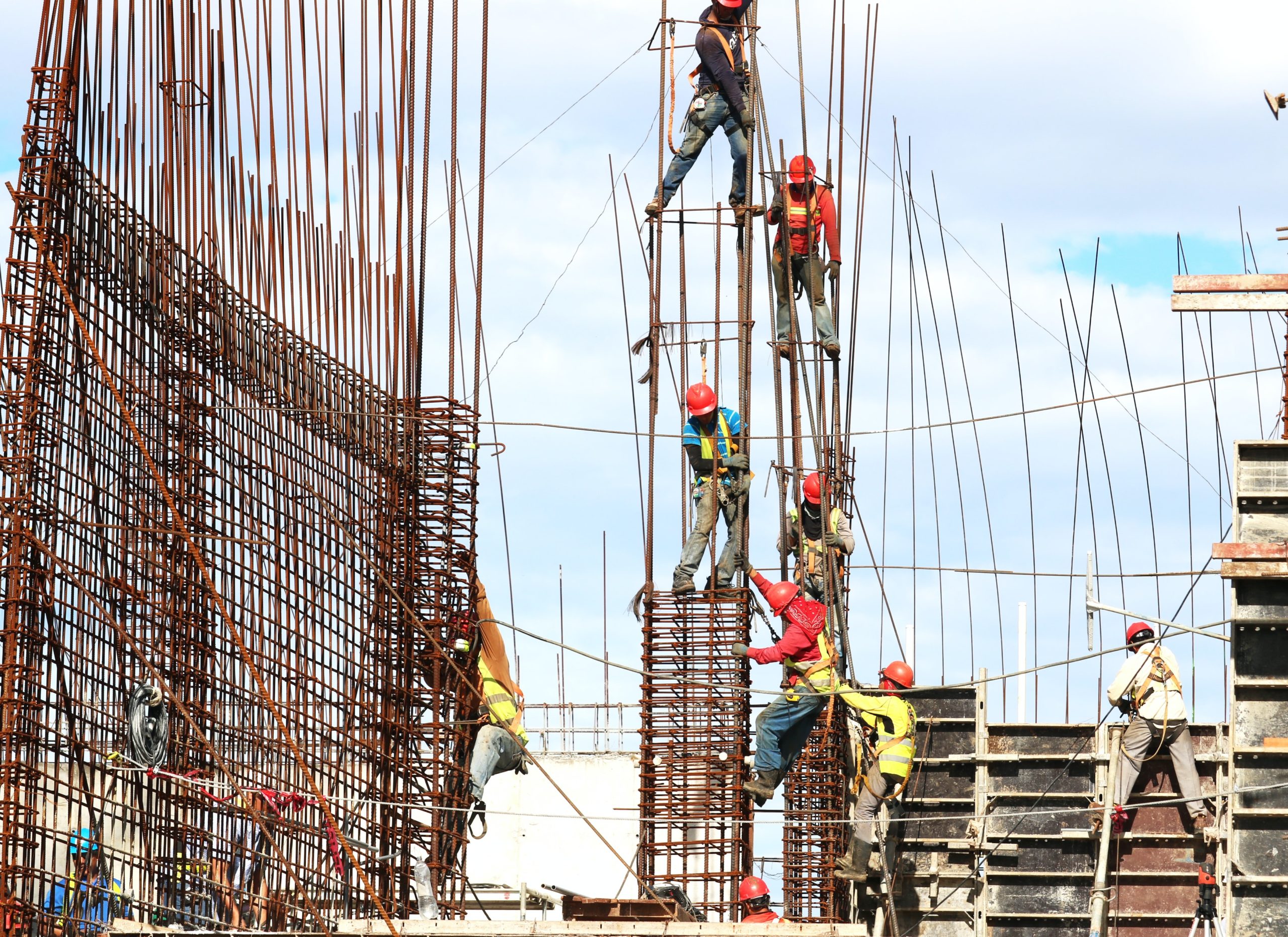 Construction workers putting up steel rods