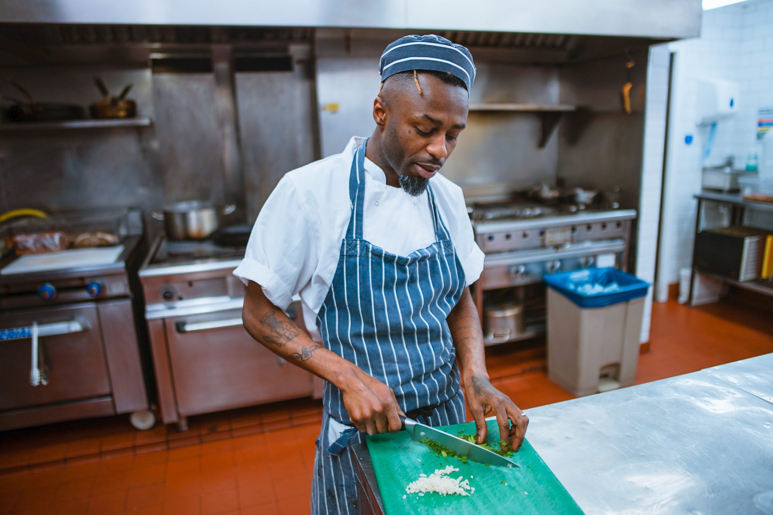 Black man cutting garlic in kitchen